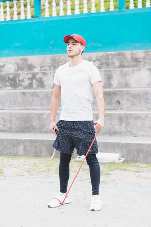 Young man doing different warm-up and cardio exercises in the park.の写真素材