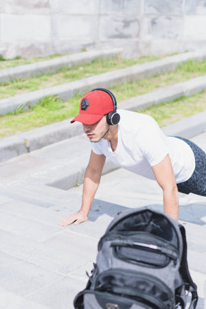 Young man doing different warm-up and cardio exercises in the park.の写真素材