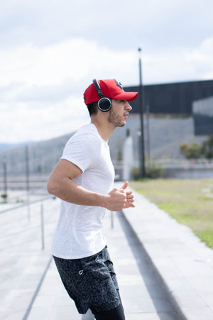 Young man doing different warm-up and cardio exercises in the park.の写真素材