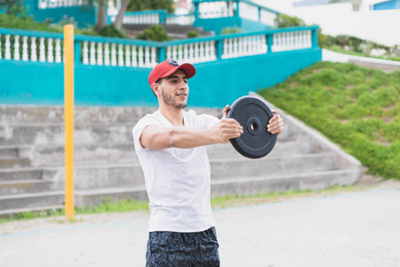 Young man doing different warm-up and cardio exercises in the park.の写真素材