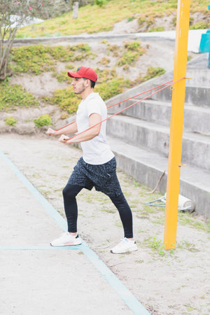 Young man doing different warm-up and cardio exercises in the park.の写真素材