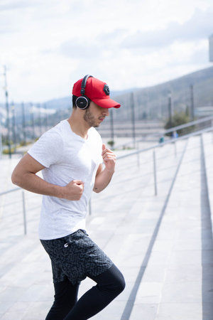 Young man doing different warm-up and cardio exercises in the park.の写真素材
