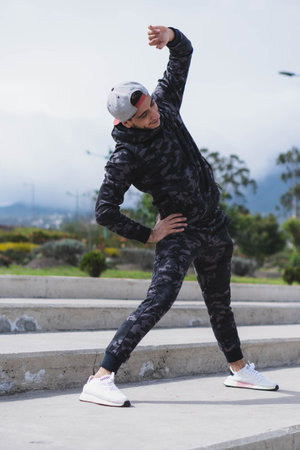 Young man doing different warm-up and cardio exercises in the park.の写真素材