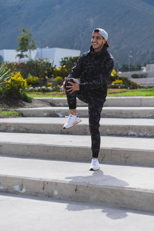 Young man doing different warm-up and cardio exercises in the park.の写真素材