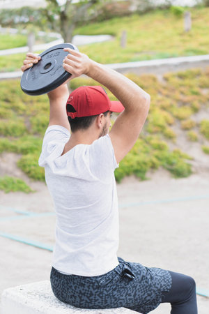 Young man doing different warm-up and cardio exercises in the park.の写真素材