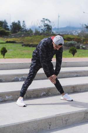 Young man doing different warm-up and cardio exercises in the park.の写真素材