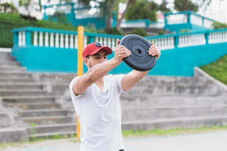 Young man doing different warm-up and cardio exercises in the park.の写真素材