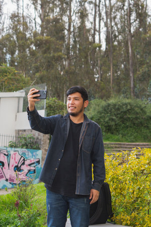Young man walking in the woods taking selfies. To show your friends.の写真素材
