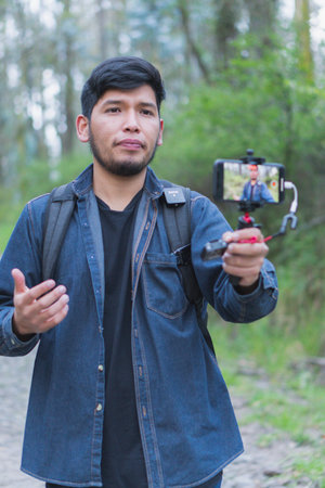 Young man walking in the woods taking selfies. To show your friends.
