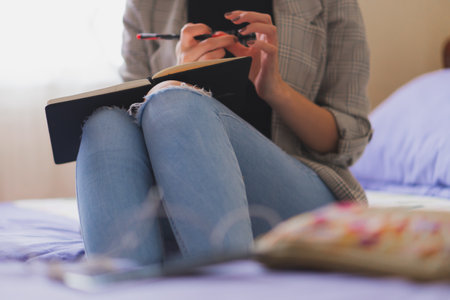 Young woman writing in her diary. Your thoughts and ideas.