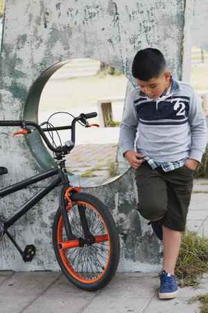 Boy riding his bike through the park enjoying the fresh air.