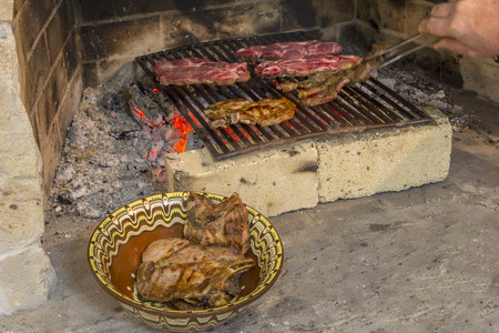 roasting fresh meat in the fireplace and bowl with steak . Make BBQの写真素材