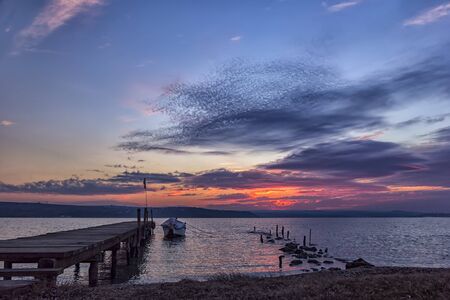 exciting sunset on a lake with bridge and boat .の写真素材