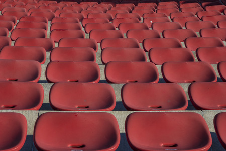 Empty plastic red chairs In outdoor theater  in sunny day. Close Up.の写真素材