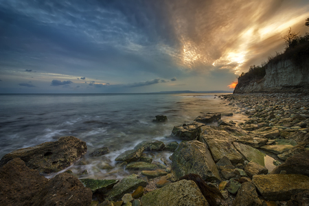 Beauty sea rocky coast with slow shutter and waves flowing out.の写真素材