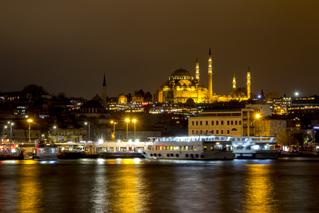 Illuminated Istanbul at night. Turkey. Night view of historical part of Sultanahmet area Famous mosques, pier with boats, cafes, bars and shops. Bosphorus river with boats.の写真素材