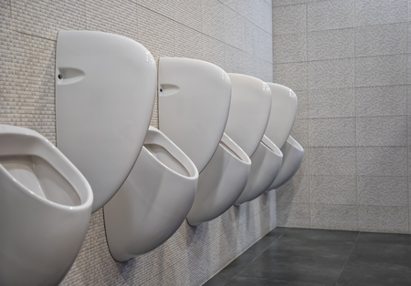 Closeup white urinals in men's bathroom, the design of white ceramic urinals for men in the toilet room. public men toilet room, WC.の写真素材