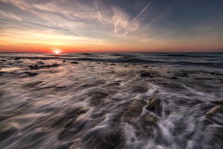 Beautiful sunrise over the sea with water motion blurの写真素材