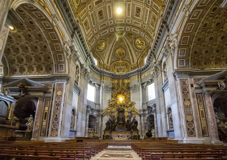 VATICAN CITY, VATICAN - JUNE 13, 2017: Altar inside St Peter's Basilica in the Vatican, nobody on the red chairs. Large beautiful hall. The altar with Bernini's baldacchino.のeditorial素材