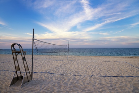 A beach volleyball net on the sandy tropical beach at the sunset / sunriseの写真素材