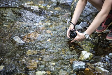 The girl makes a photo or video with a camera from the shore.の写真素材