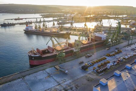 Aerial view from the drone of a large ship loading grain for export in the harbor. Water transportの写真素材