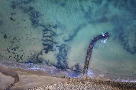 Aerial top view from drone to the seacoast and old concrete pier, Sea background.