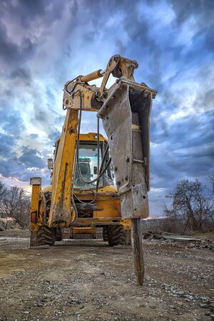 Excavator with hydraulic breaker hammer for the destruction of concrete and hard rock at the...