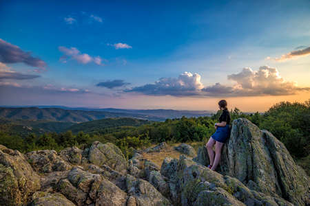 A young girl enjoys a beautiful view from top .Travel in the mountains.の写真素材