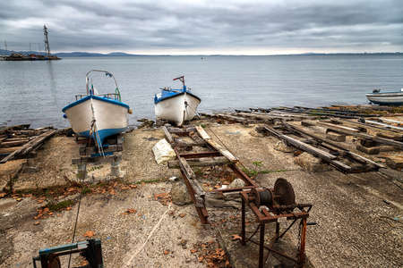 Pier with fishing boats moored on the shoreの写真素材