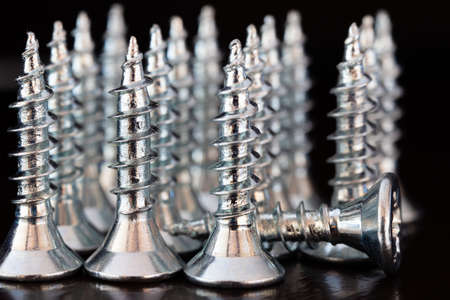 Close up of screws on a black background. Advertising photo