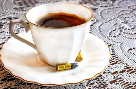 Still life with coffee cup and bullets on the table