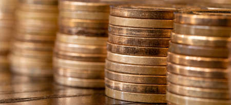Banner with piles of coins on the table. Coins side view. Coins macro shot.