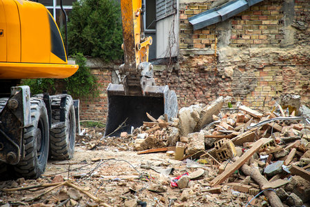 Excavator breaks old house. Freeing up space for the construction of a new buildingの写真素材