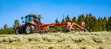 Processing silage with tractor in the field. Preparation of food for animals for the winter.の写真素材