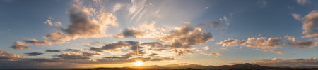 Dramatic clouds and sun in the sky at sunset