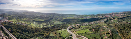 Amazing panoramic view from a drone of a landscape with part of a road junction near the sea.の写真素材