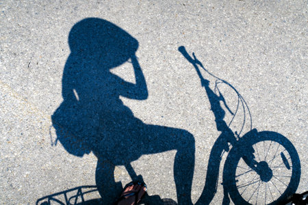 Shadow of cyclist stopping for rest on a bicycle on a roadの写真素材