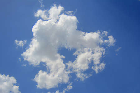 in a large white interesting form the cloud is seen about the approach of rain in the sky above the blue colorの写真素材