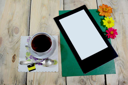 A beautiful cup of iced tea is placed on a table made of worn wood, on the table there is a teaspoon and a napkin.の写真素材