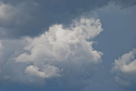 in a large white interesting form the cloud is seen about the approach of rain in the sky above the blue colorの写真素材