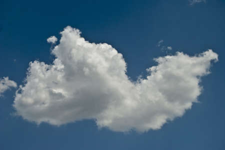 in a large white interesting form the cloud is seen about the approach of rain in the sky above the blue colorの写真素材