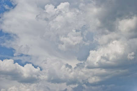 in a large white interesting form the cloud is seen about the approach of rain in the sky above the blue colorの写真素材