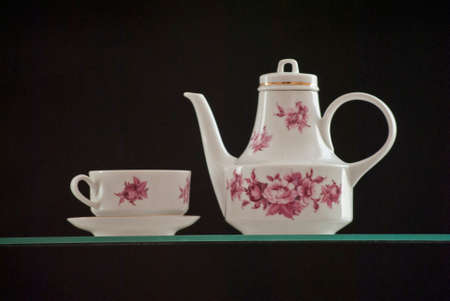 On a black background, you can see a very beautiful teapot and a cup of tea.の写真素材