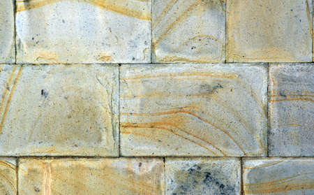 Rectangular basalt wall worn over time, different parts of the stone have taken on different colors, a beautiful background can be used for various design purposes.の写真素材