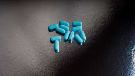 Blue pills on a gray-black background.