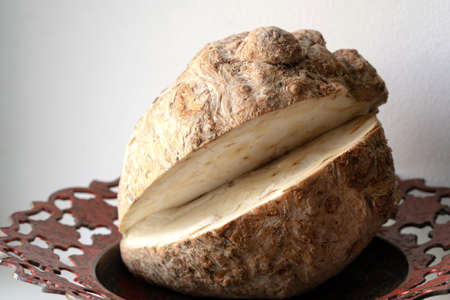 Celery root on a metal plate with an ornament in natural light.