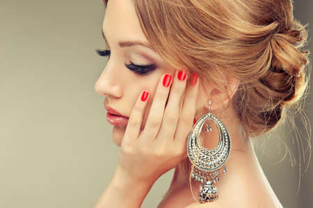 Beautiful model with red manicure and elegant hairstyleの写真素材