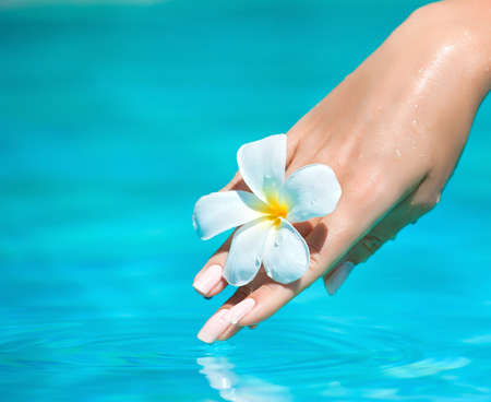 Graceful woman hand touching pure water. Hand care.の写真素材