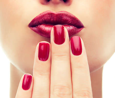 Beautiful model shows red manicure on nails. Red lips .Luxury fashion style, manicure nail ,...